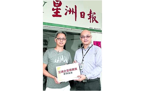 Wong Cheong Loong (L) handing over the 2015 Sin Chew Business Excellence Awards nomination forms to Sin Chew's manager for Perak. Photo courtesy: Sin Chew Daily