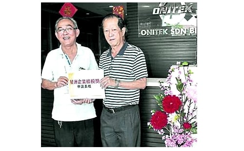 Sin Chew Daily's Muar office chief (R) handing over the nomination forms to Lau Lam Leong. Photo courtesy: Sin Chew Daily