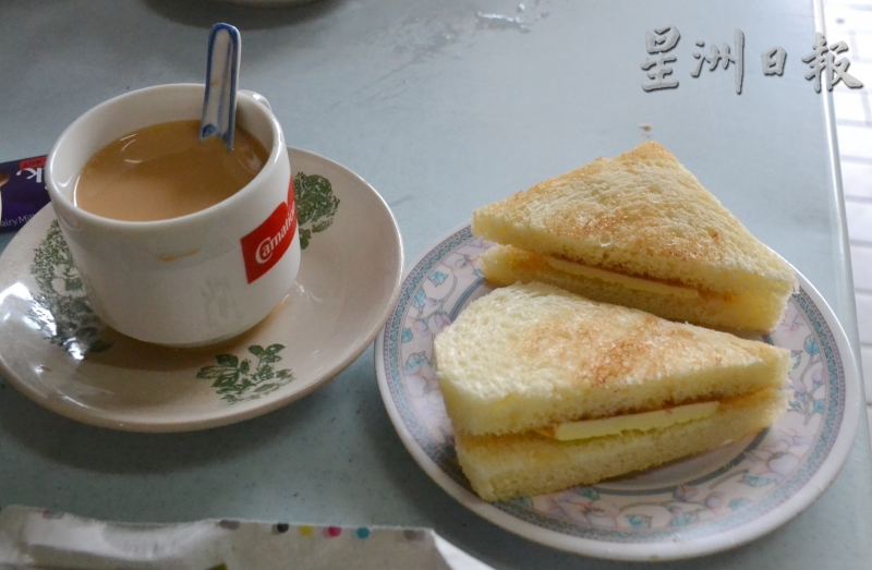 新美珍茶室的顺滑奶茶（左起）和自制烤面包，乃食客必尝之道地美食。（图：星洲日报）