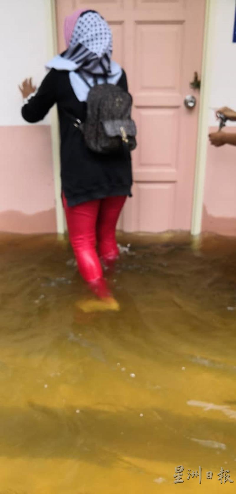 妇女动身前往中心前，把住处大门锁好，当时，水位的高度已经淹至小腿位置。