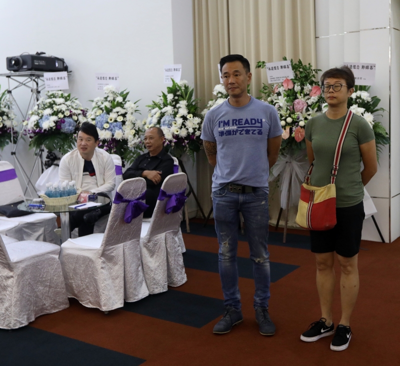 HVD艺人薛鸣（左）在灵堂上，看着昌哥的遗照，神情凝重。