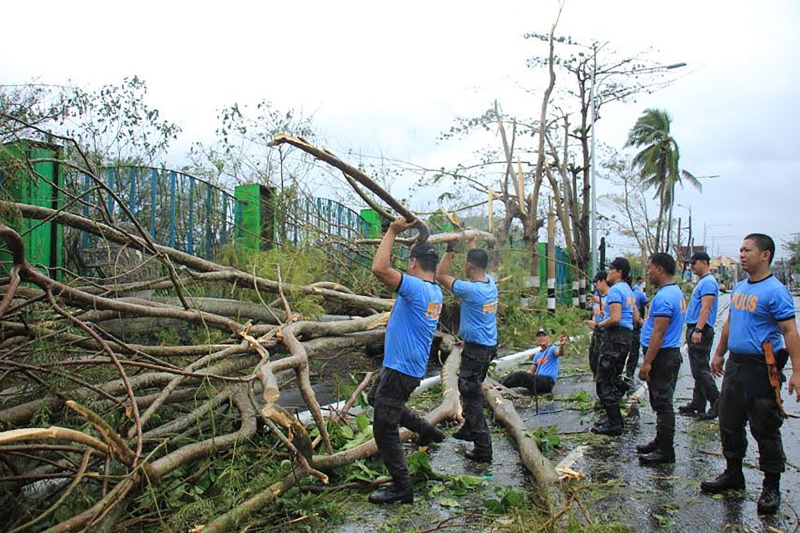 “北冕”强风吹倒了菲律宾南部黎牙实比的树木，菲律宾当局赶紧出动警力进行善后工作。（图：法新社）