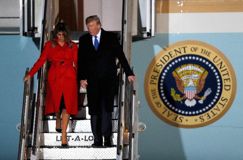 美国总统特朗普和夫人兰妮周一晚抵达英格兰斯坦斯特德机场，两人手牵手步下舷梯。（图：法新社）