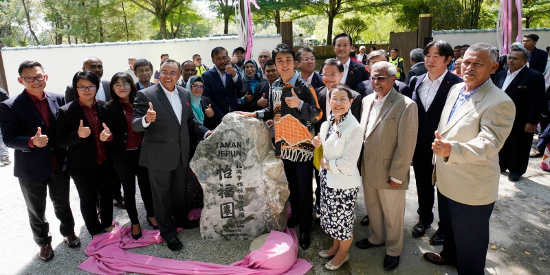 阿末苏艾迪（左四）和高岛宗一郎（右六）及两市的代表们在怡福园新的石碑上合照。