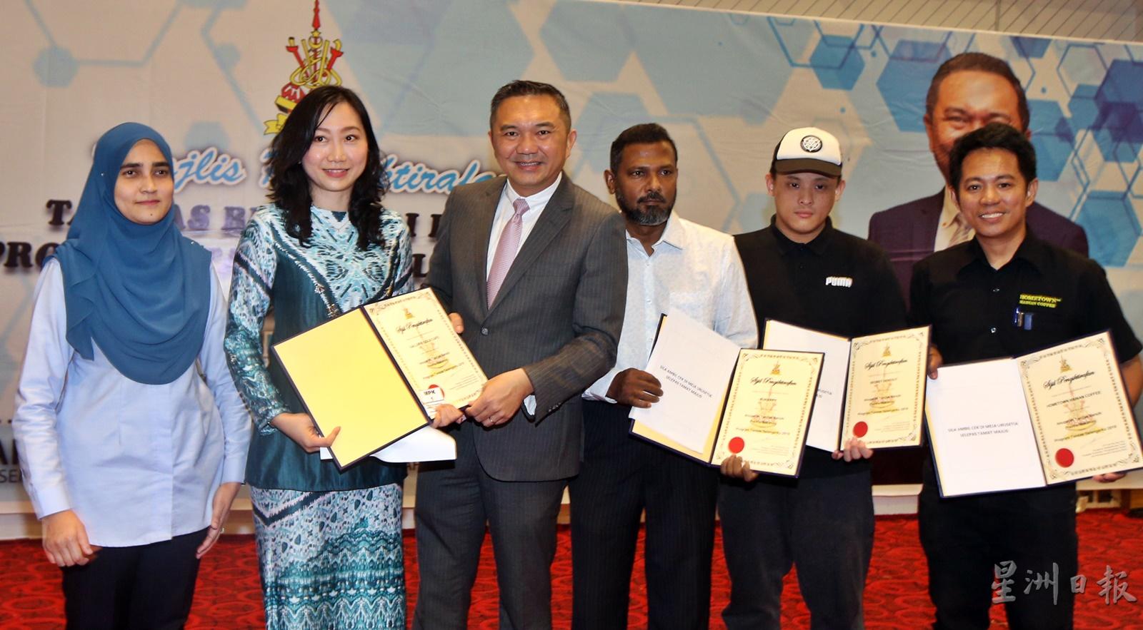 黄思汉（左三）颁发我的雪兰莪清洁厕所奖状给获奖食肆业者。