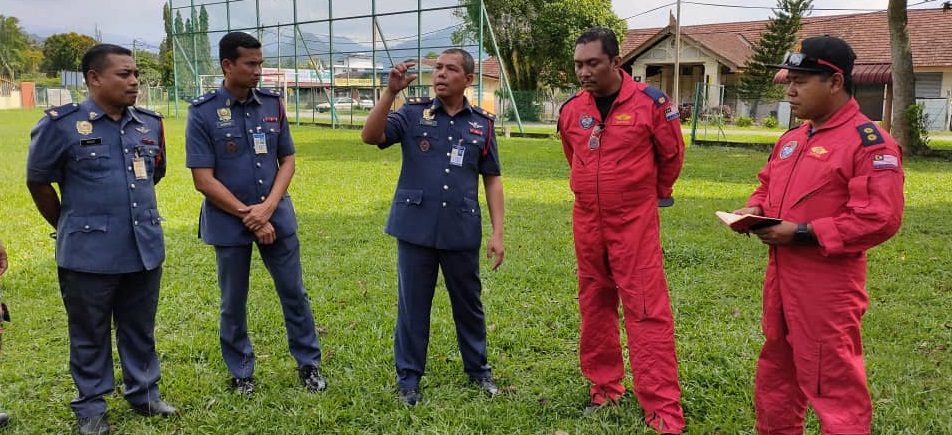 消拯局官员与搜救人员讨论搜寻结果，确定并无发现直升机坠落的迹象；中为莫哈末尤努斯。