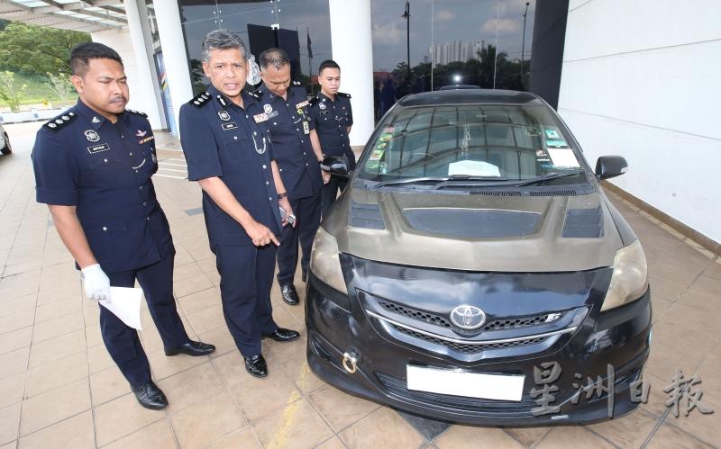 依斯马迪（左二）向媒体展示警方起获的丰田轿车。