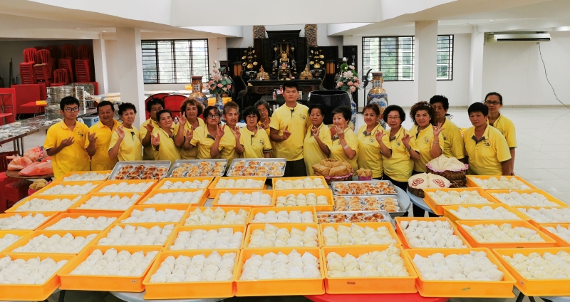 “吉祥义工团队”为慈善活动制作包子、面包及糕点，从不计较辛苦与劳累；右九为潘来吉。