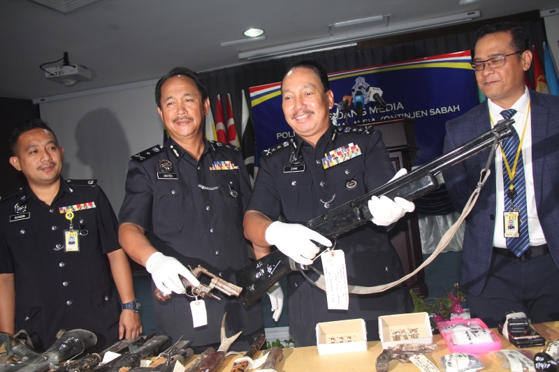 再尼（左二）展示警方歼灭枪匪后起获的土枪。