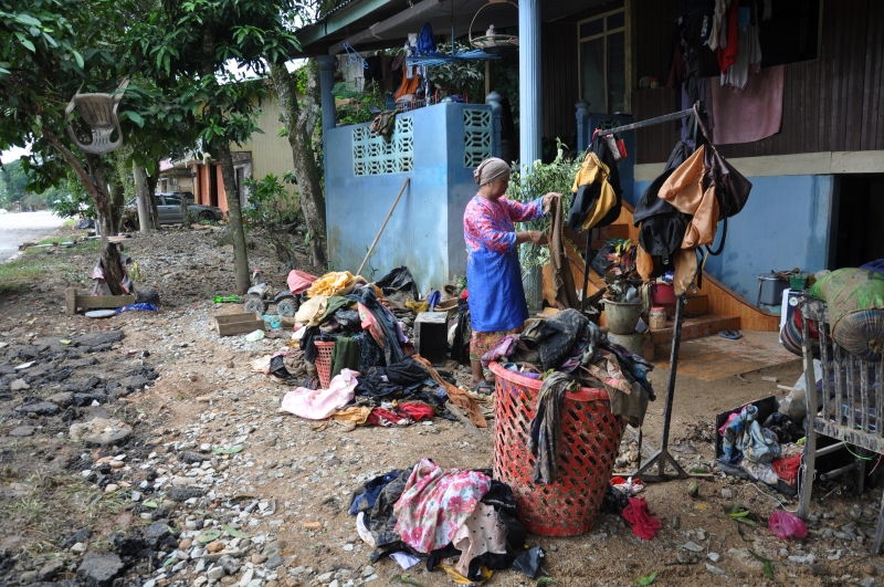 登州乌鲁勿述的灾民卡雅蒂（54岁）于灾后重返家园，整理被水泡过的衣服。