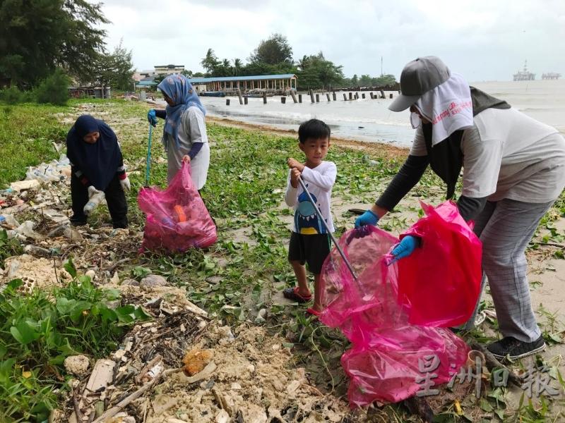义工们在沙滩上捡拾垃圾。