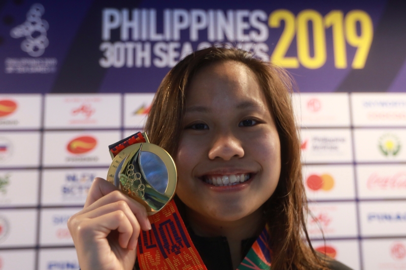 在连续2届东运屈居银牌后，彭靖恩周五终于在菲律宾东运一圆女子50公尺蛙泳金牌夙愿，也是大马在这届东运的游泳首金。图为彭靖恩在颁奖典礼上兴奋展示其战果。