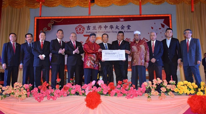 哈山（左六）代表移交1万5000令吉摸拟支票给丹华堂，同行者包括丹州行政议员旺罗斯兰（右四）。