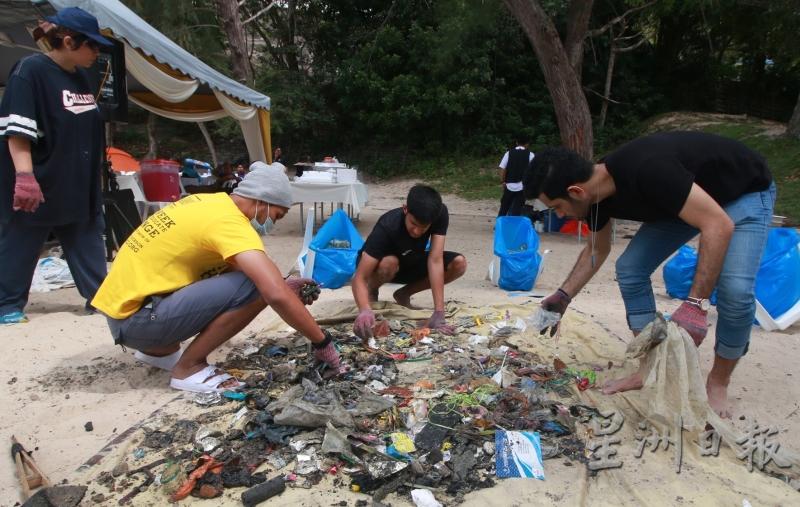 海滩清洁运动结束后，工作人员把垃圾进行分类。（图：星洲日报）