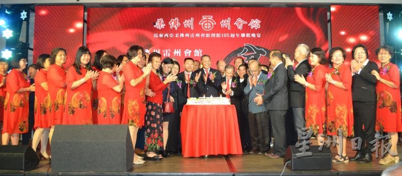 苏国光（中）带领全体董事、青年团及妇女组理事共切105周年纪念蛋糕。（图：星洲日报）