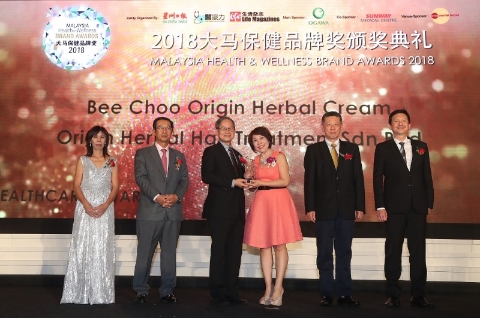 谢美珠从卫生部副部长李文材手中接过大马保健品牌奖。