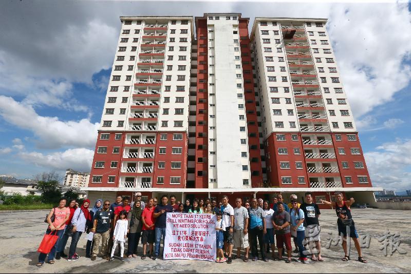 王诗棋（左十一）与逾30名购屋者在美福园中价公寓楼下拉横幅展开和平请愿，呼吁地主现身解决问题。