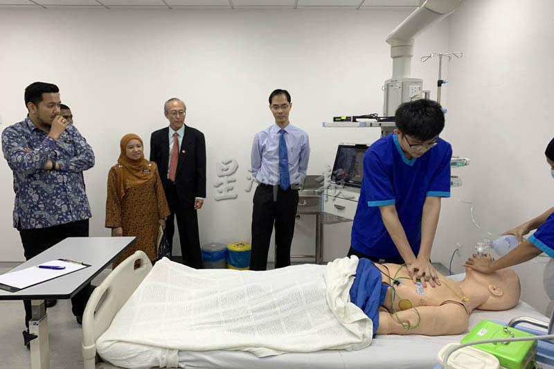 阿菲夫（左）参观模拟医疗室，左三是刘爱明。
