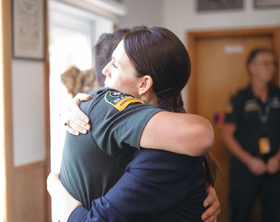 纽西兰总理阿恩周二访登瓦卡塔尼消防局时，拥抱一名协助火山爆灾难伤者的急救人员表示谢意。（图：法新社）