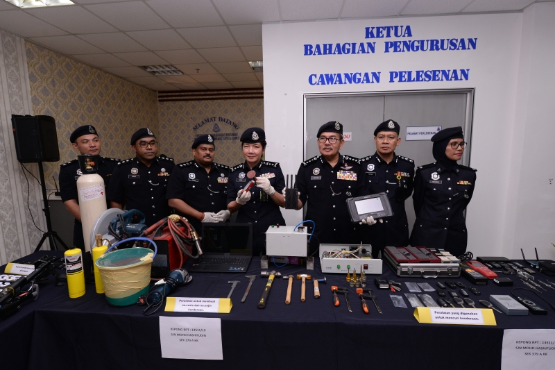 马兹兰（右三起）与吉隆坡副总警长拿督杨丽珠以及一众建功警官展示警方所起获的干案工具及贼赃。