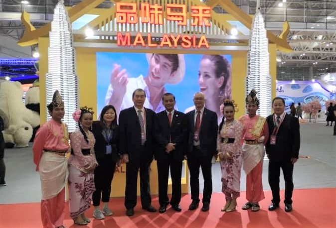 邱财加(右五)，马福青商主席刘国景(右一)及马来西亚参展商和文化艺术团成员在品味马来展馆前合影。