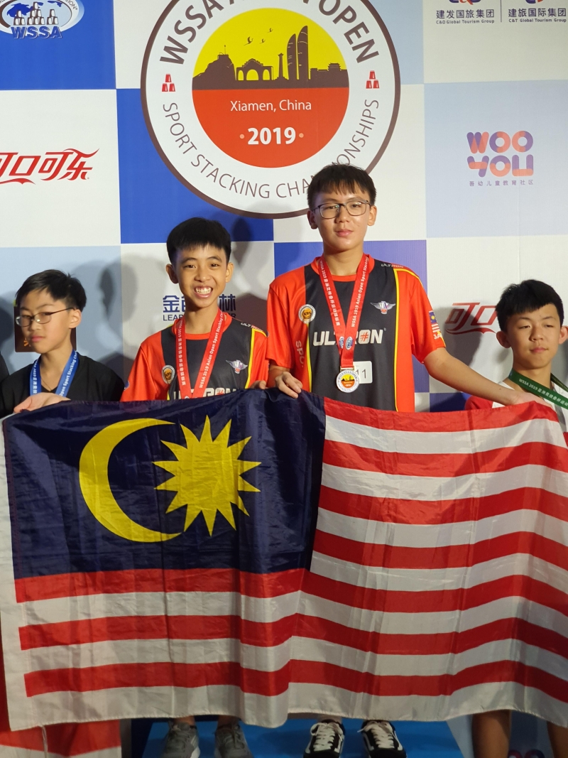 在大力推广及给予培训下，马来西亚出了不少叠杯高手，其中包括选手陈敬贤（右二）及王俊贤（左二）勇夺双人赛亚洲总冠军。

