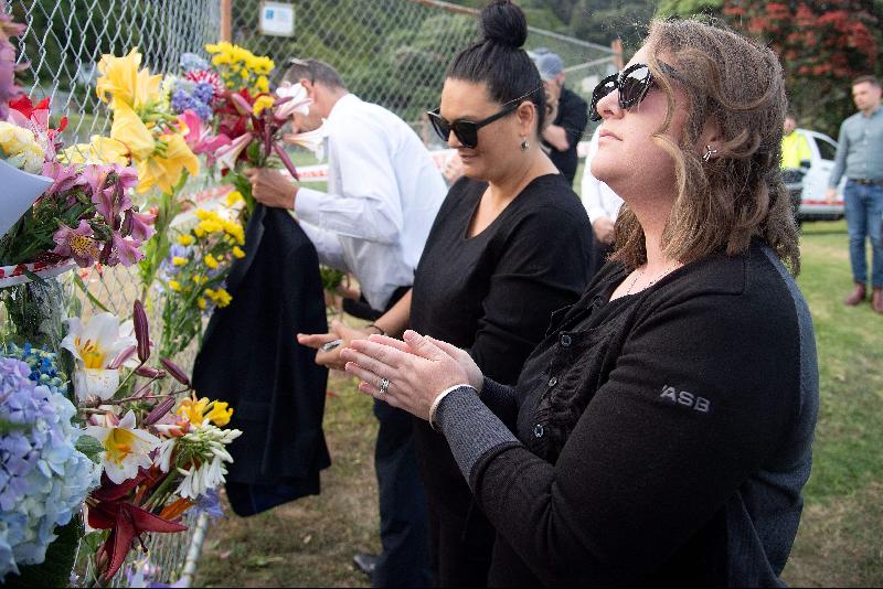 图为丰盛湾的怀特岛旅行社外，有民众放置鲜花、字条悼念遇害者。（图：法新社）