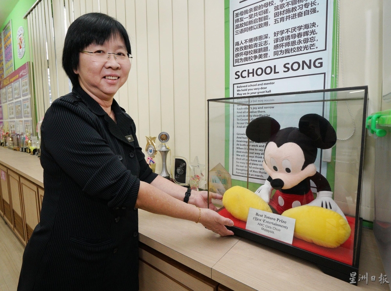 歌咏队资深顾问老师潘丽莹展示于香港迪斯尼乐园第4届国际冬季合唱节比赛所获得的奖项。（图：星洲日报） 