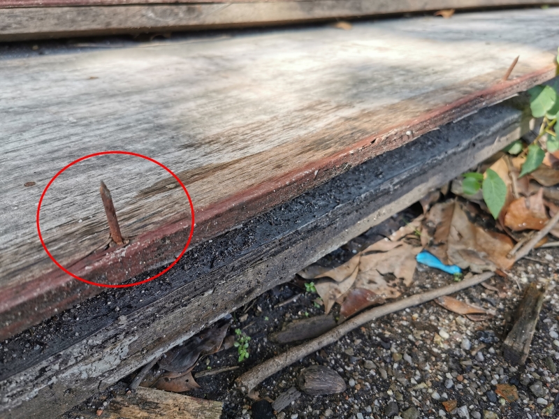 横放在地的木板留下生锈铁钉。