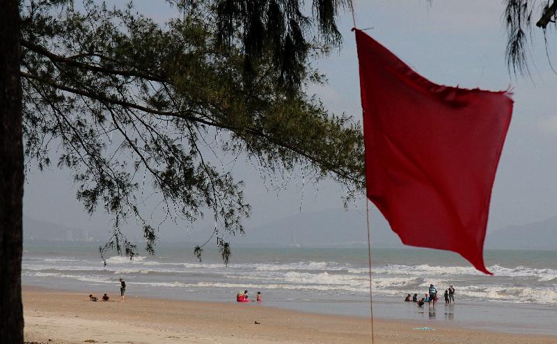 红旗扬起仍然见到游客在海边戏水。
