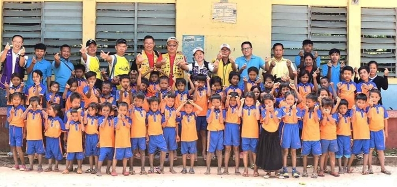林敏倩（后排左八）等人到柬埔寨送暖给乡区的贫苦孩童。