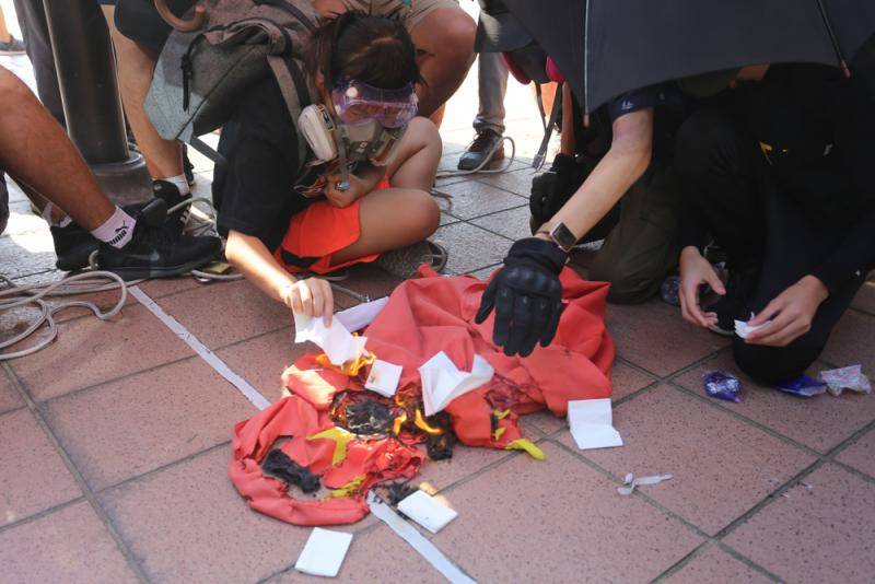 9月21日游行期间，13岁女生在屯门大会堂外焚烧五星红旗。（图取自互联网）