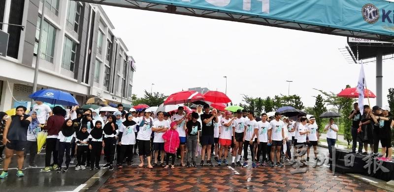 逾百名义跑参与者不畏风雨“为关爱而走”，勇气及精神可嘉。（图：星洲日报）