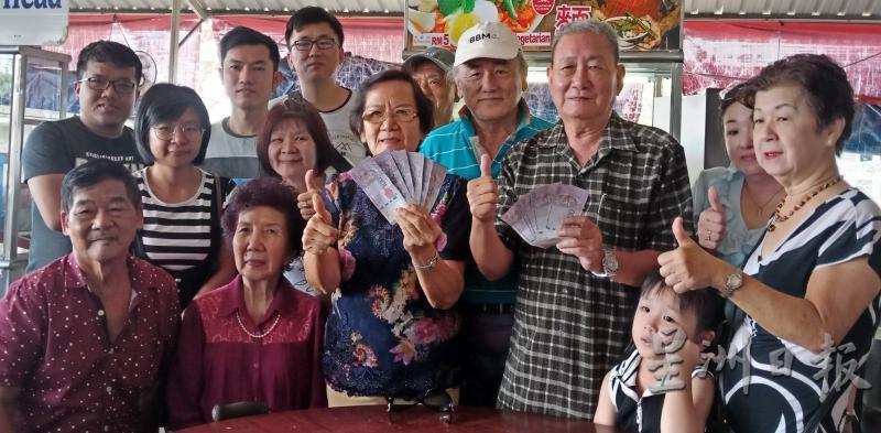 槟城三民校友会总务郭秀春（前排左三）代表移交义款给骆天明。