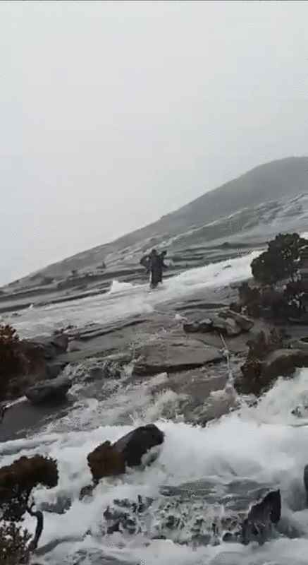 登山客周日凌晨征服神山后遇上滂沱大雨，一度受困在山腰，险象环生。（视频截图）