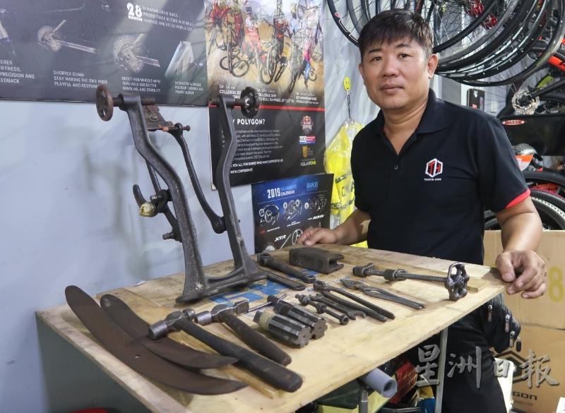 许俊祥展示祖父和父亲留下的修理脚车工具。（图：星洲日报）