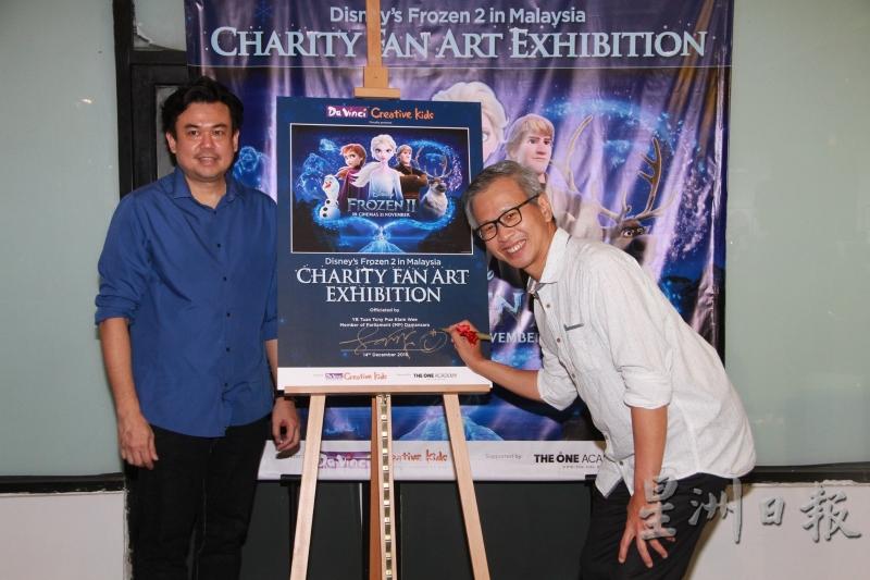 潘俭伟（右）为“冰雪奇缘2来到马来西亚”慈善美术展主持开幕仪式，左为陈源隆。（图：星洲日报）