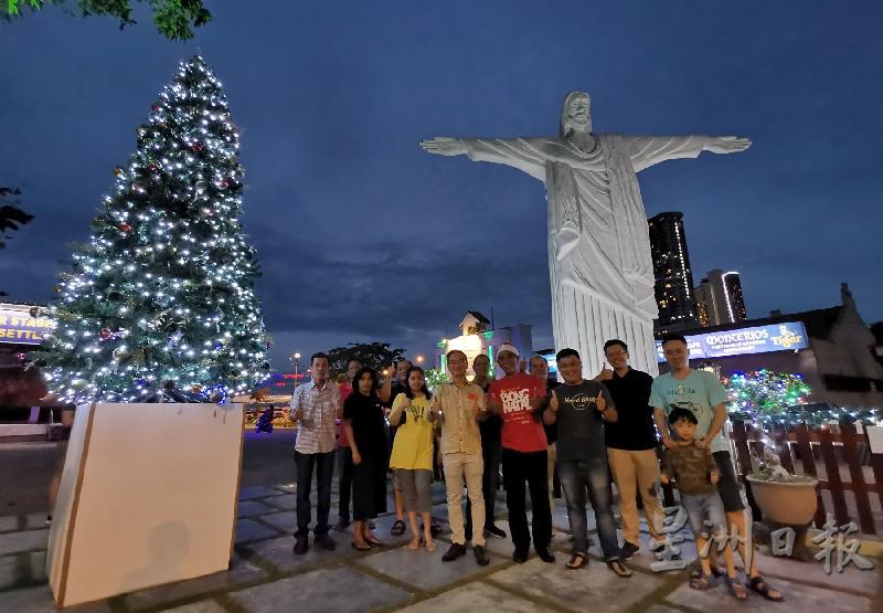 邱培栋（左四）、马丁（左五）与团队及游客一起感受葡村的圣诞气氛，后为30呎高的耶稣雕像。