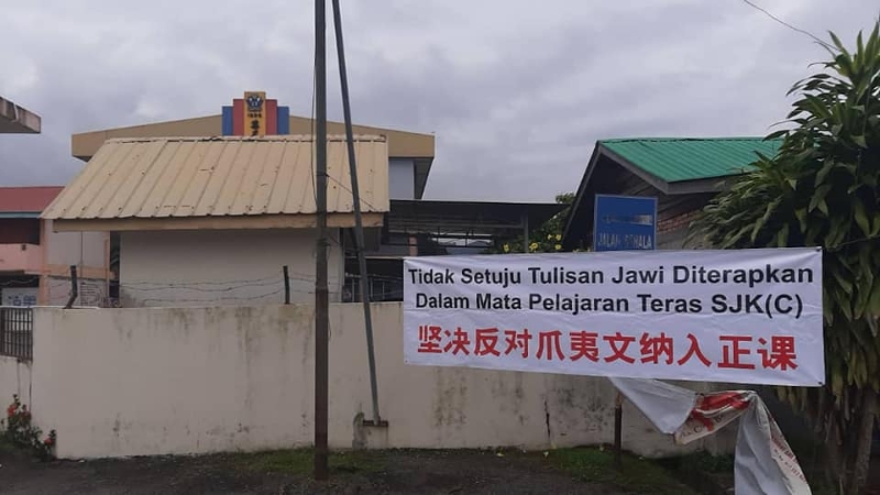 乌鲁音峇鲁葛尼华小校外挂有的“反对爪夷文纳入正课”横幅，在张挂不足24小时就被有心人士拆下。（取自脸书）