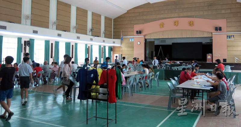 槟城钟灵中学在礼堂设柜台，让新生办理入学登记以及解答家长们的相关提问。