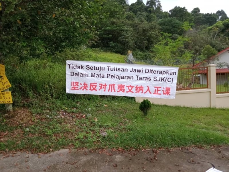 爱美乐华小的布条是挂在校外候车处旁。