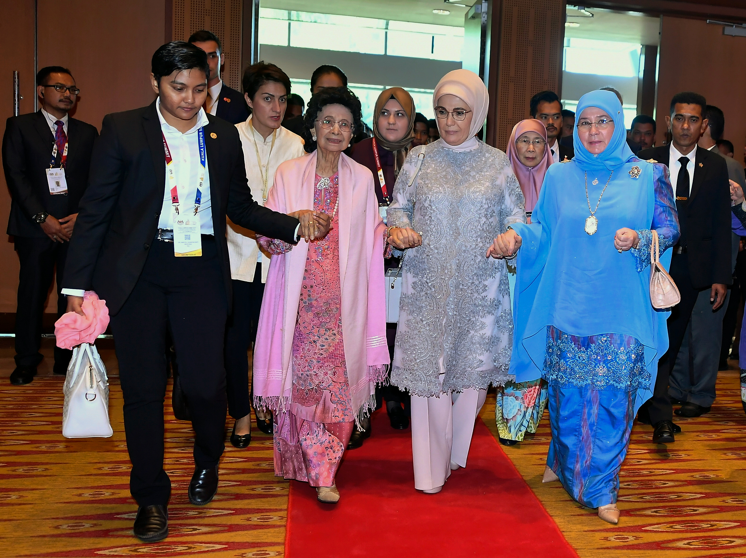 有朋自远方来，不亦乐乎。国家元首后东姑阿兹莎阿米娜（右）与首相夫人敦茜蒂哈斯玛（左二）与土耳其总统夫人伊敏情同姐妹，互相扶持走红地毯出席吉隆坡峰会开幕典礼。