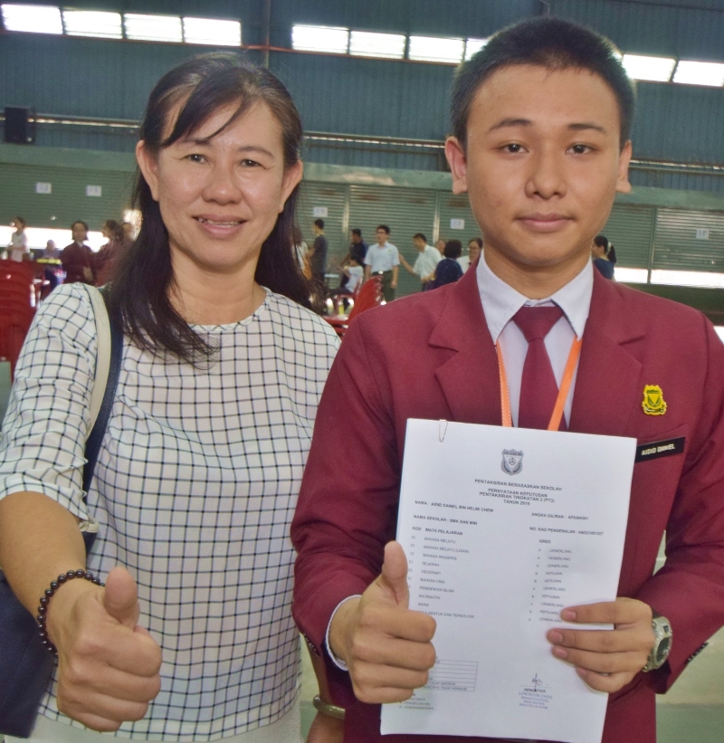 周柏霖(右)华文考获A等，获得华文老师陈平燕的赞赏。