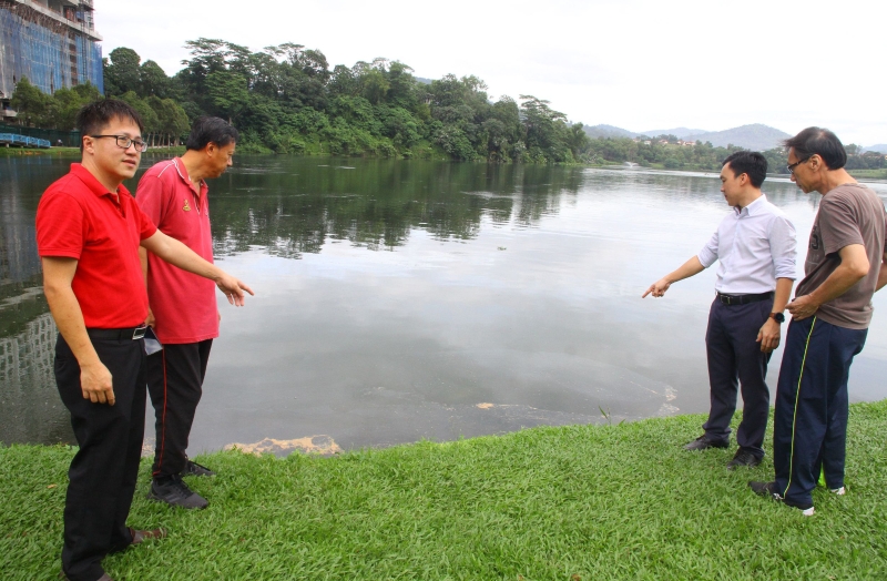 吴茂明（左二）联同其他居民及公园晨运客带记者巡视湖水受污染的情况。