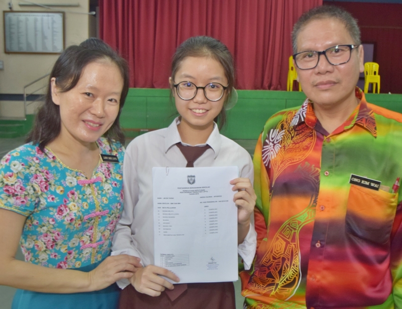 林紫彤考获9A佳绩，接受副校长王剑伟(右)及老师刘美玲(左)的祝贺。