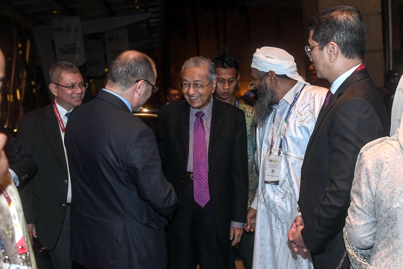 首相马哈迪（中）在晚宴上与各国代表握手问好。右一为经济事务部长拿督斯里阿兹敏；左一为外交部长拿督赛富丁。