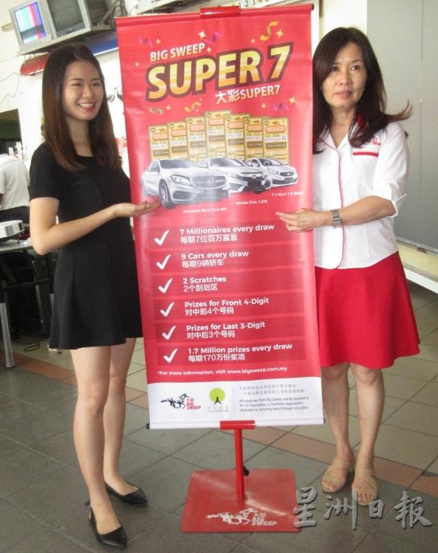 大彩Super 7第S4/19彩期开彩，洪彩凤（右）和大彩Super 7女郎王小桐展示海报中的名贵车奖品。
