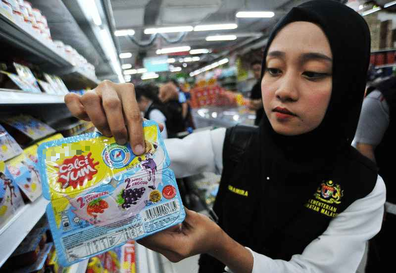 纳闽卫生局官员展示一家超市出售的逾期食品。