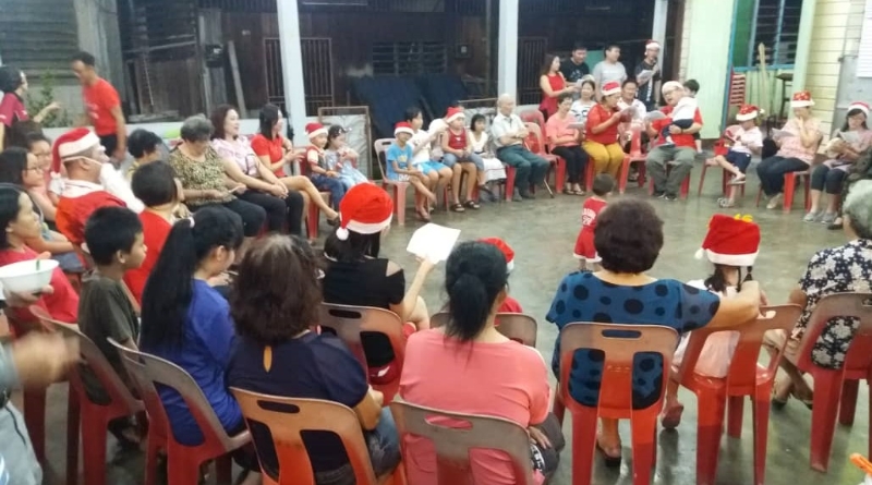 出席十八丁圣伯多禄天主堂圣诞晚会的教友，围绕一起唱圣歌报佳音。