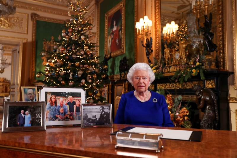 英国经历多事的一年，英女王伊丽沙白在预先录制的圣诞献词中承认，今年对其家庭及全国来说都是“崎岖不平”的一年，但相信可逐步改变。图为女王在温莎堡录制献词，眼尖的网民发现桌上少了哈里及梅根的照片。（法新社照片）